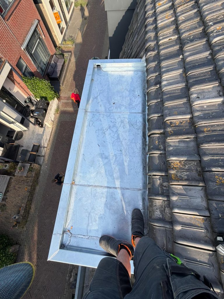 Nieuwe zinken dakkapel met strak afgewerkte zinken bekleding op een woning in Zandvoort